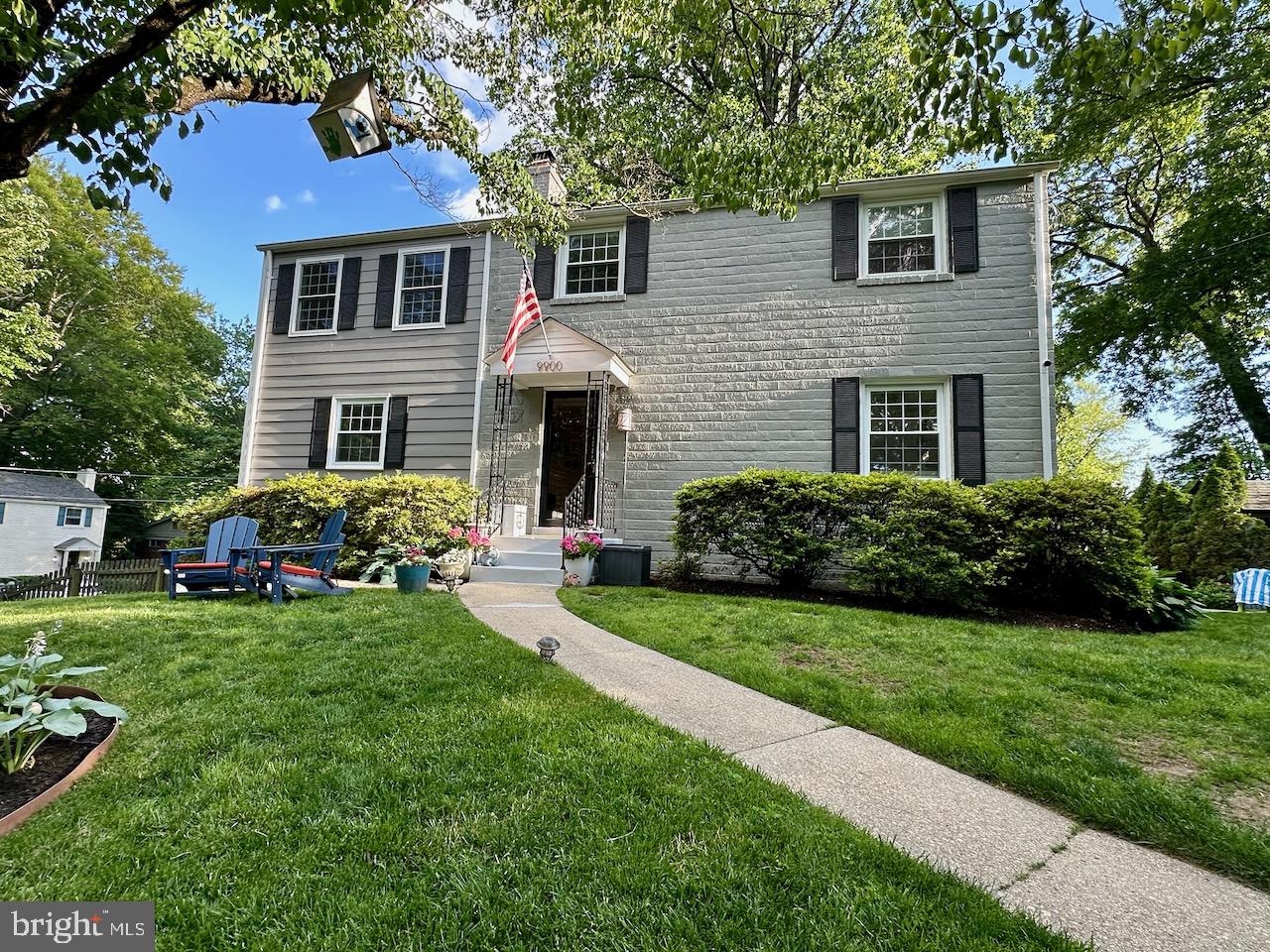 9900 Woodburn Road Silver Spring, MD 20901 - Photo 1 of 1 a front view of a house with a garden and trees