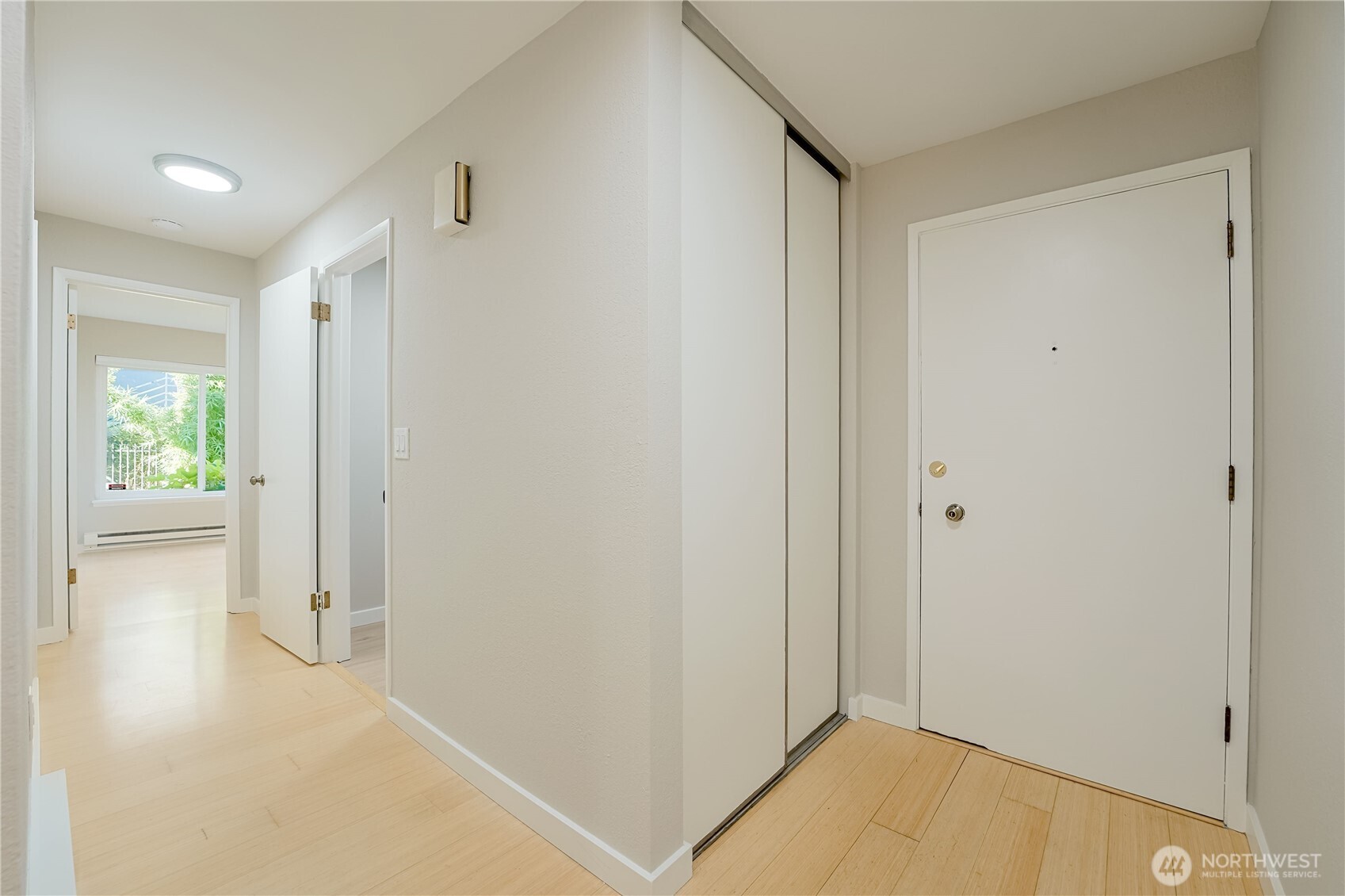 1100 South Atlantic Street, Unit 209 Seattle, WA 98134 - Photo 19 of 31 a view of a hallway with wooden floor and a bathroom
