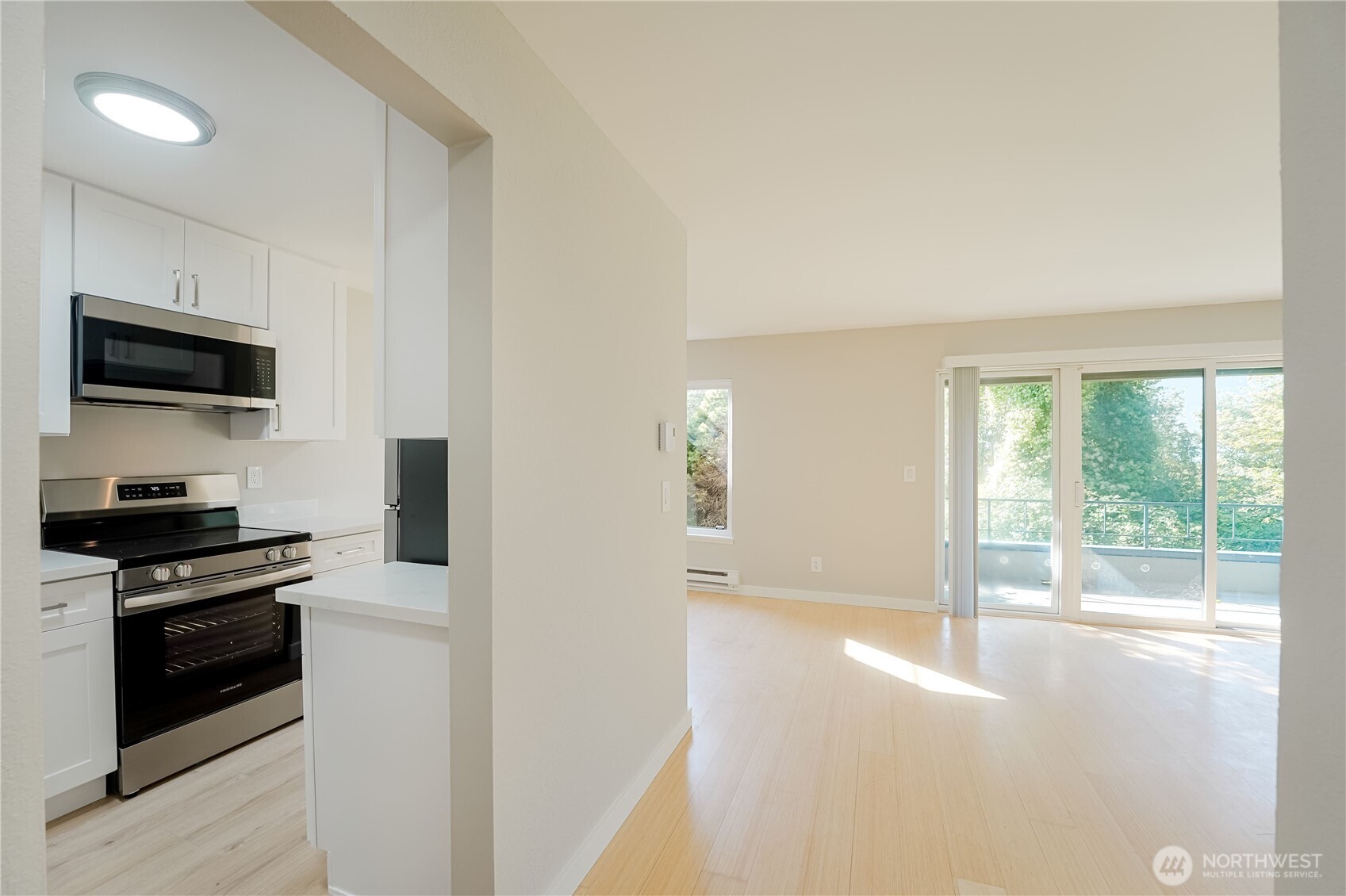 1100 South Atlantic Street, Unit 209 Seattle, WA 98134 - Photo 8 of 31 a kitchen with a stove a microwave and a view of living room
