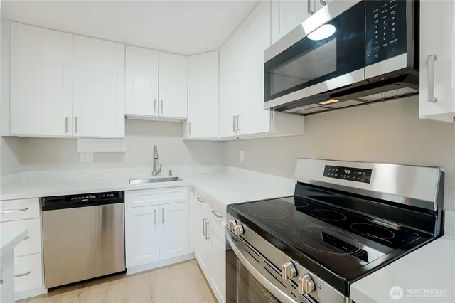 a kitchen with stainless steel appliances a stove a microwave and cabinets