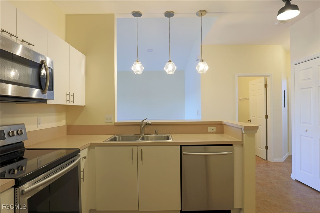 4199 Bellasol Circle, Unit 622 Fort Myers, FL 33916 - Photo 9 of 27 a kitchen with a sink a stove and cabinets
