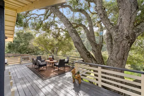 a view of a patio with table and chairs a barbeque with wooden floor and fence
