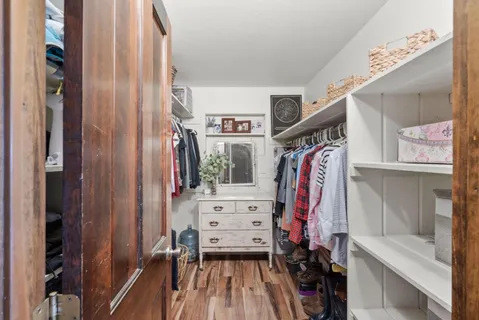 a view of walk in closet with clothes and shoes