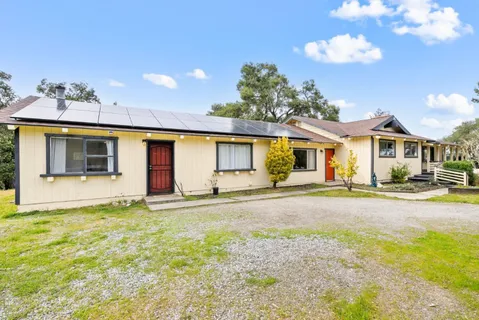 a view of a house with a patio and a yard