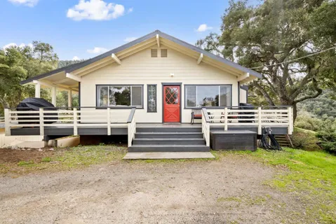 a front view of a house with a yard table and chairs