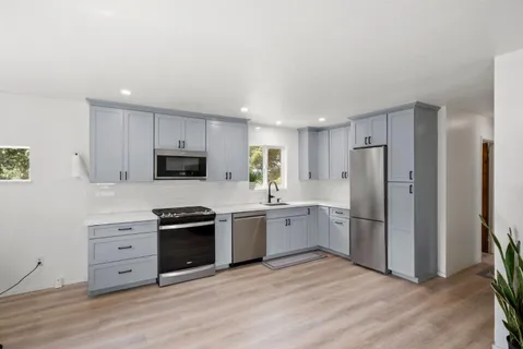 a kitchen with stainless steel appliances granite countertop a refrigerator stove and sink