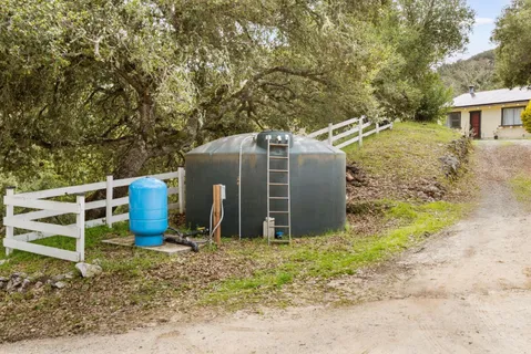 a view of a wooden house with large trees