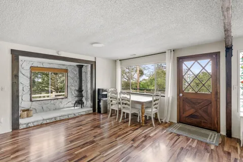 a dining room with furniture and wooden floor a rug