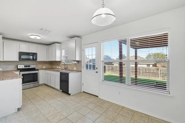 a kitchen with a refrigerator and a stove top oven