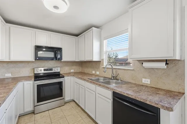 a kitchen with stainless steel appliances granite countertop a sink stove and microwave