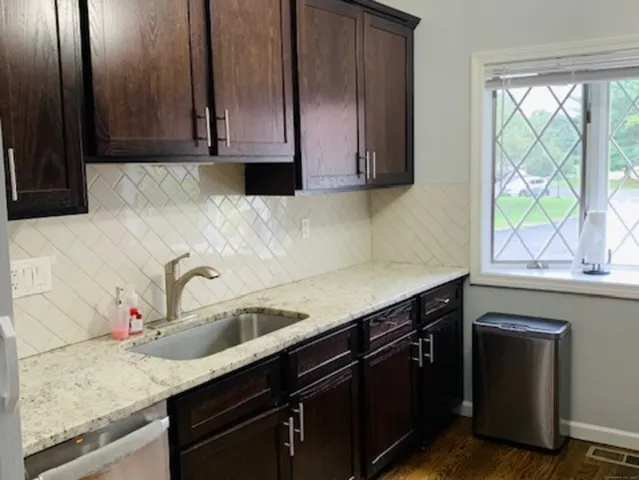 a kitchen with granite countertop cabinets and window