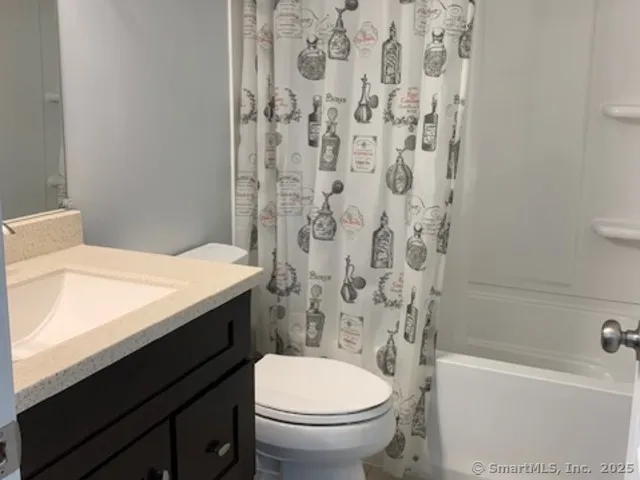 a bathroom with a granite countertop toilet a sink and a bathtub