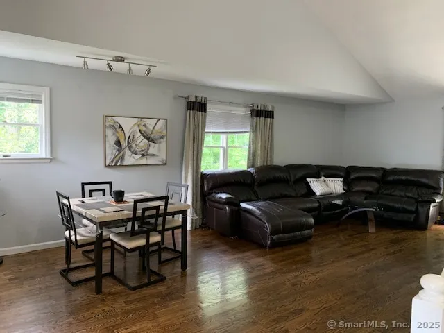 a living room with furniture wooden floor and a window