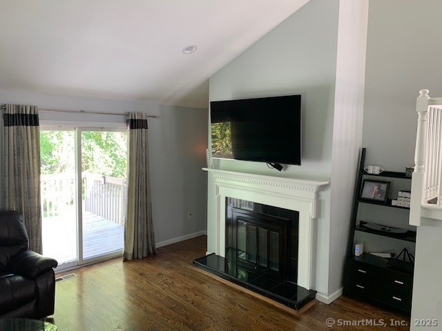 81 The Meadows, Unit 81 Enfield, CT 06082 - Photo 5 of 18 a living room with a fireplace and a flat screen tv