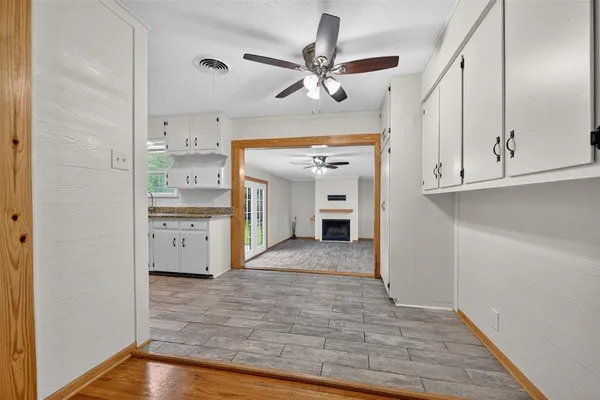 a view of a hallway with wooden floor and cabinets