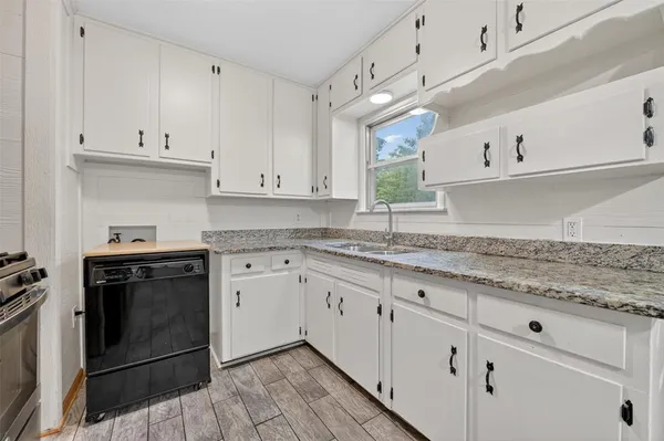 a kitchen with granite countertop white cabinets and white appliances
