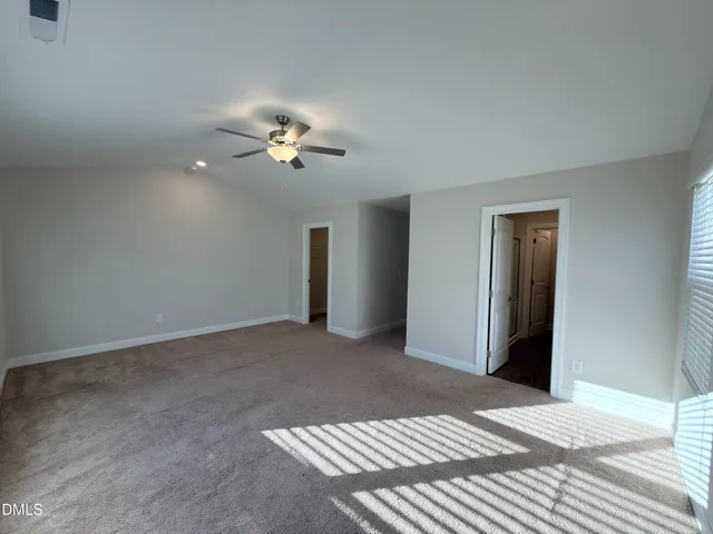 a view of a bedroom with a ceiling fan and a chandelier fan