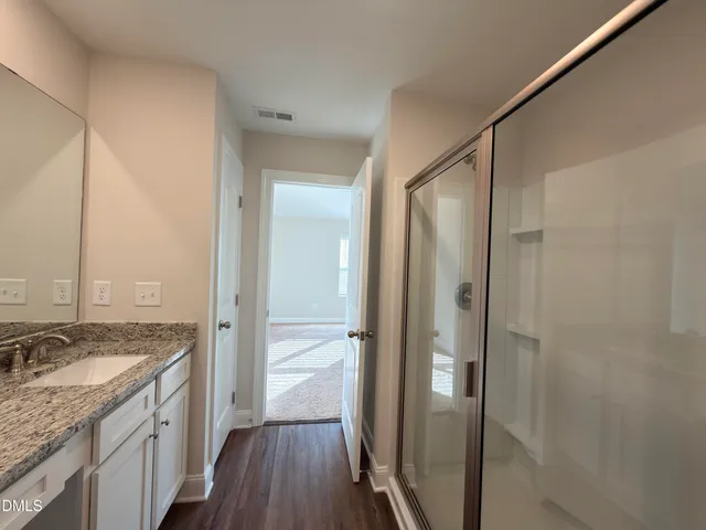 a bathroom with a granite countertop sink mirror and shower