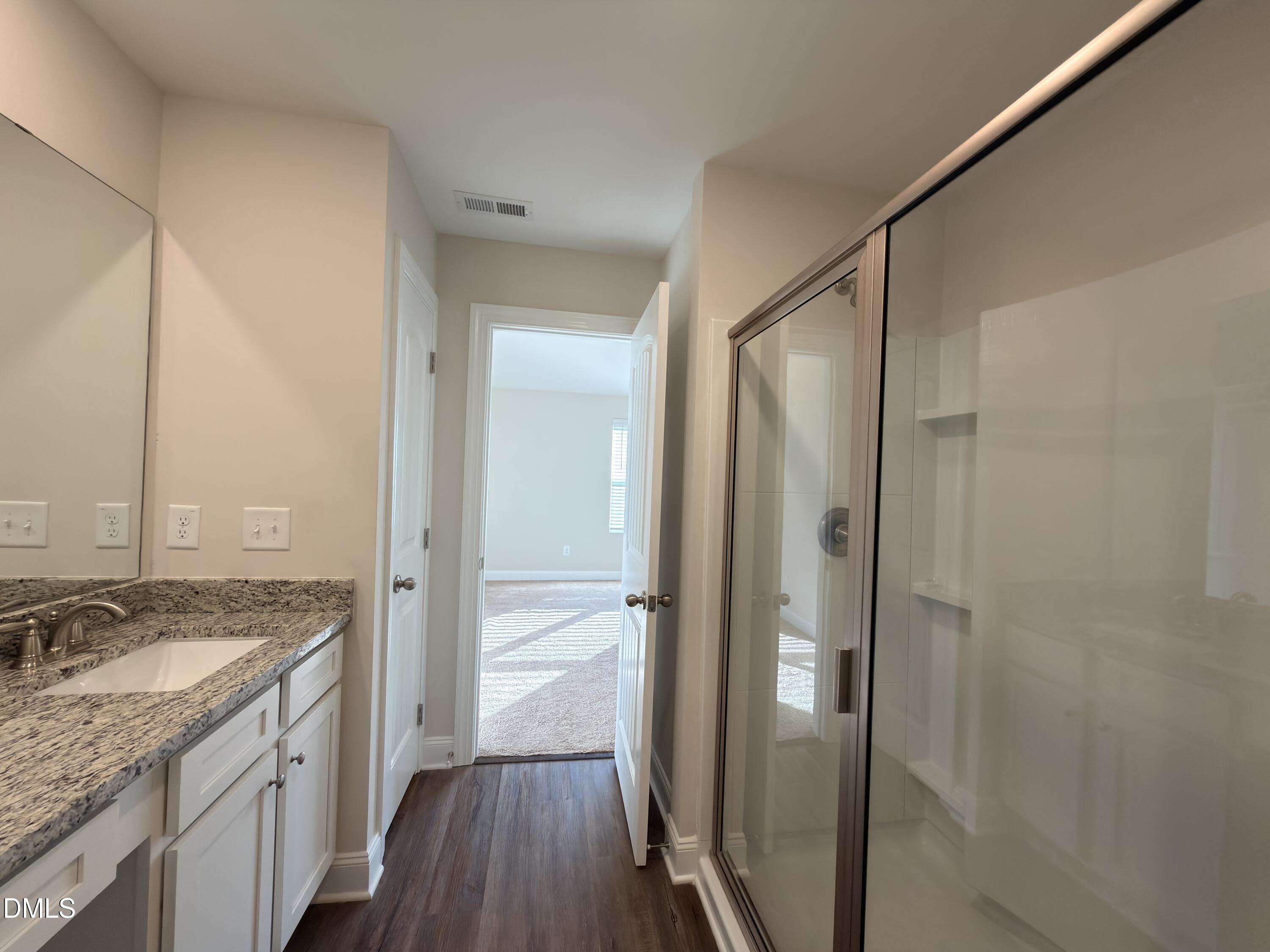 6928 Outfall Point Lane Raleigh, NC 27616 - Photo 16 of 33 a bathroom with a granite countertop sink mirror and shower