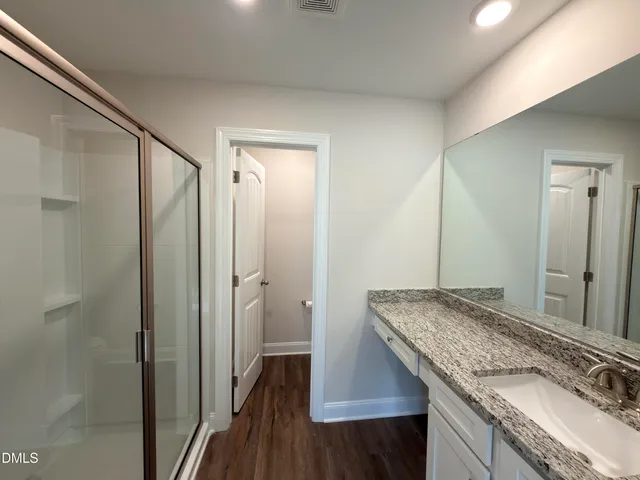 a bathroom with a granite countertop sink and a mirror