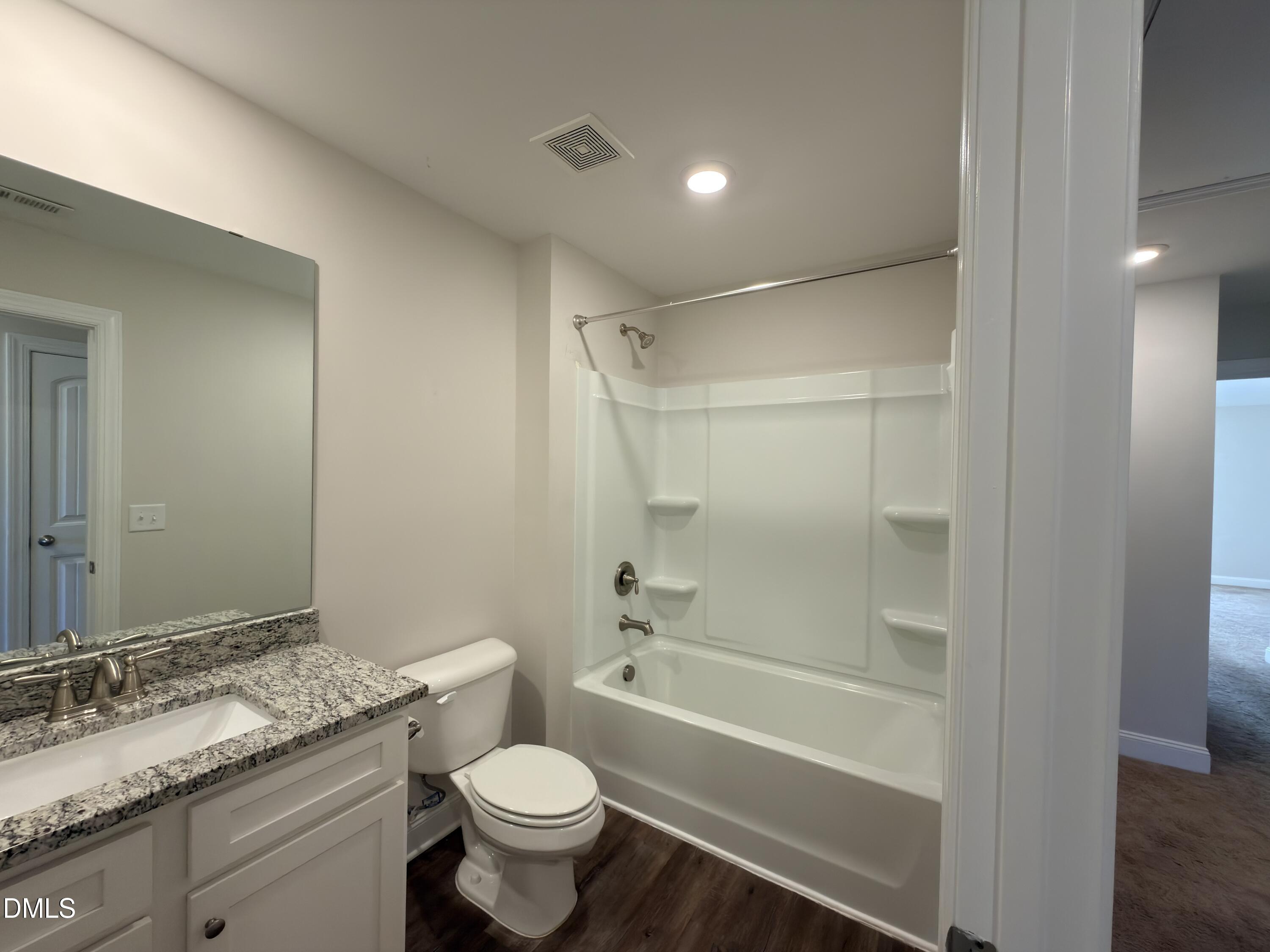 6928 Outfall Point Lane Raleigh, NC 27616 - Photo 20 of 33 a bathroom with a granite countertop sink toilet mirror and bathtub