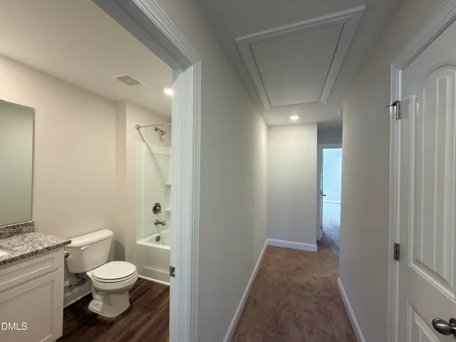 a bathroom with a granite countertop toilet a sink and a mirror