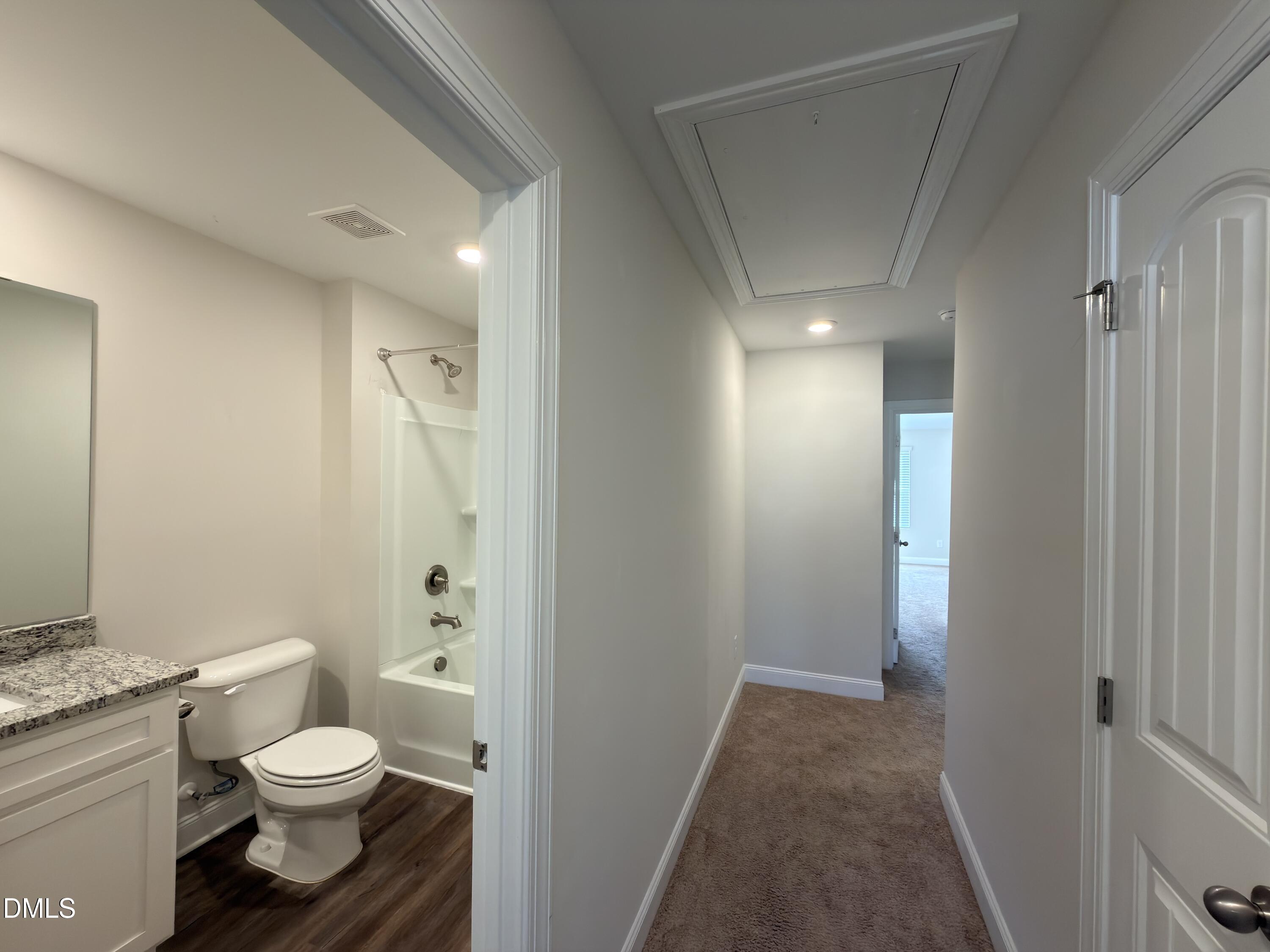 6928 Outfall Point Lane Raleigh, NC 27616 - Photo 21 of 33 a bathroom with a granite countertop toilet a sink and a mirror