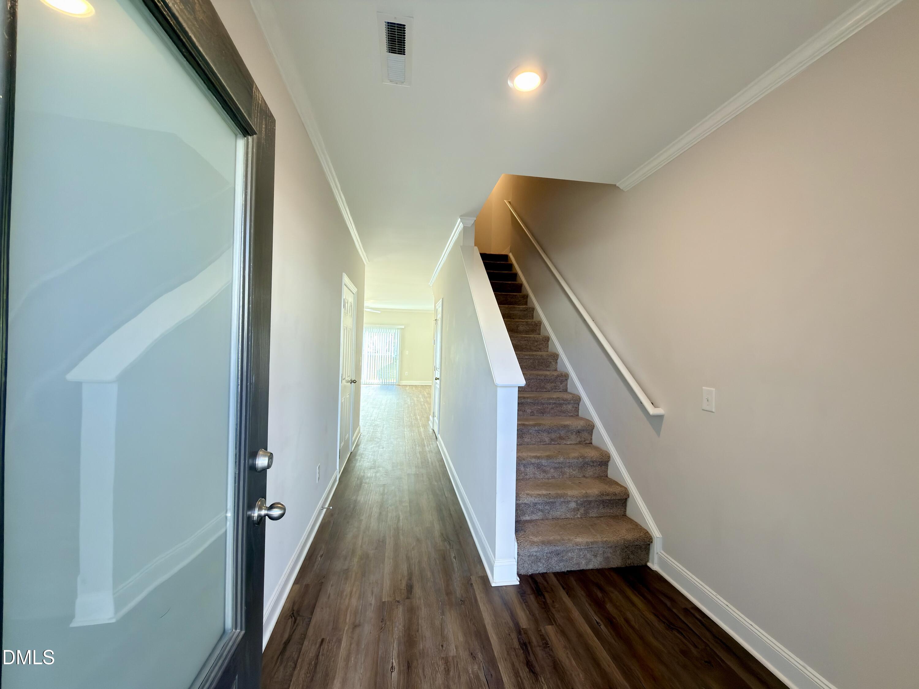 6928 Outfall Point Lane Raleigh, NC 27616 - Photo 4 of 33 a view of a hallway with wooden floor and staircase