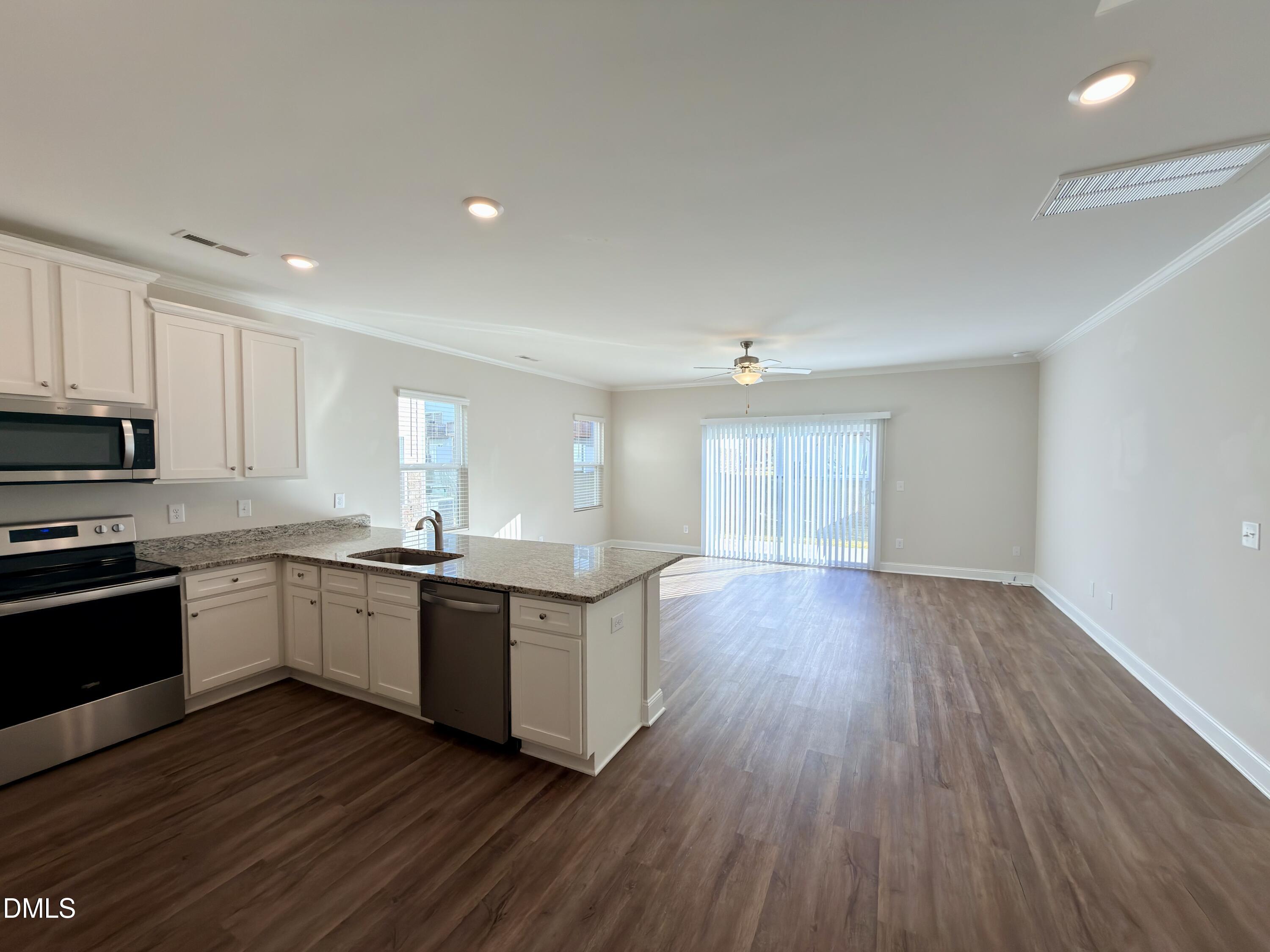 6928 Outfall Point Lane Raleigh, NC 27616 - Photo 5 of 33 a kitchen with wooden floors and appliances