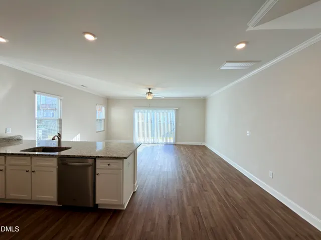 a kitchen with granite countertop a sink and wooden floor