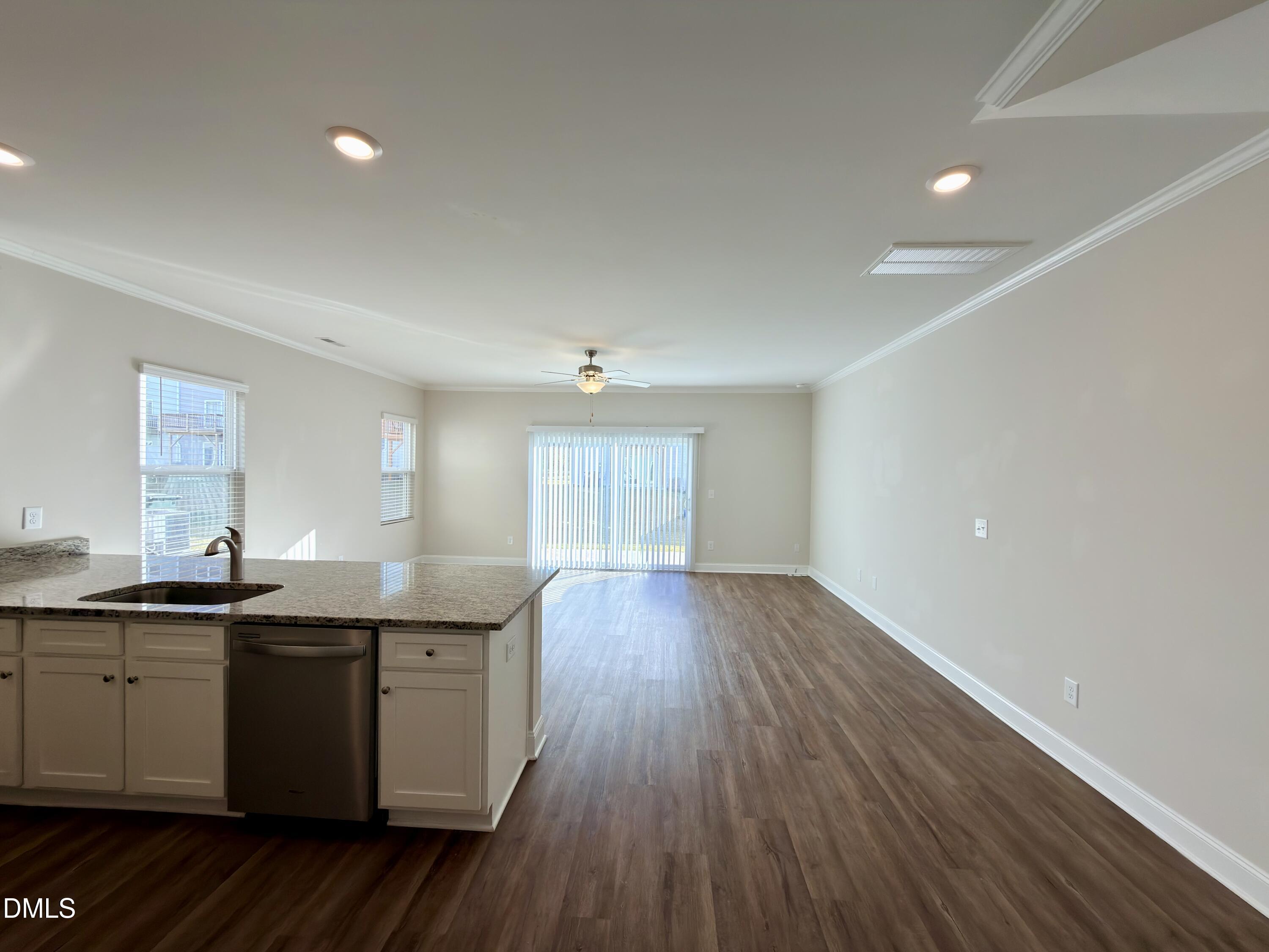 6928 Outfall Point Lane Raleigh, NC 27616 - Photo 7 of 33 a kitchen with granite countertop a sink and wooden floor