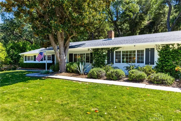 a front view of a house with a yard and green space
