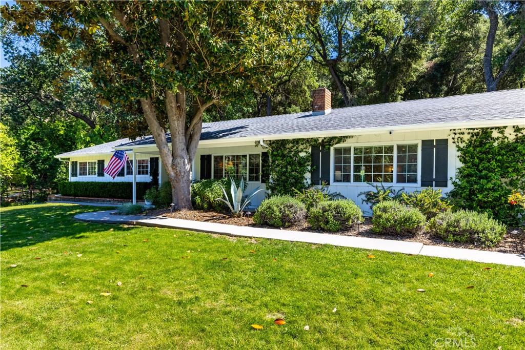 a front view of a house with a yard and green space