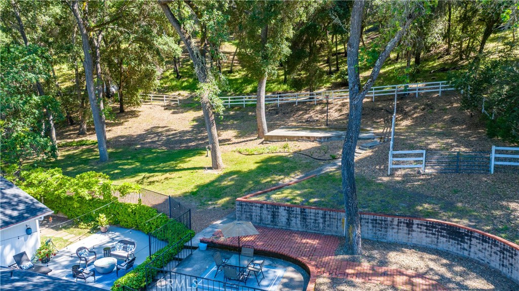 7695 Del Rio Road Atascadero, CA 93422 - Photo 66 of 75 a view of a backyard with table and chairs and wooden fence