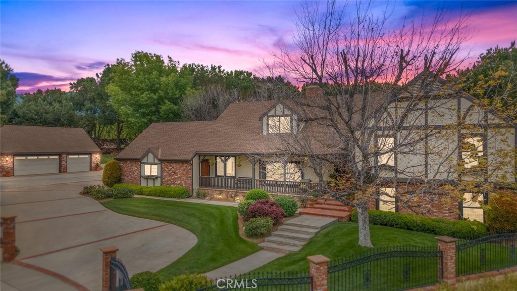 A sprawling tri-level home with brick detailing, a three-car garage, and manicured landscaping.