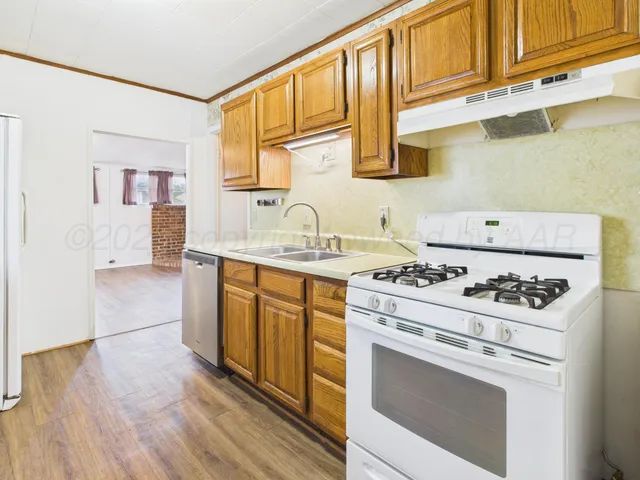 a kitchen with stainless steel appliances a stove a sink and a microwave