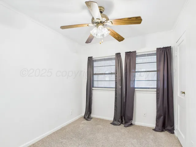 a view of a room with closet and ceiling fan