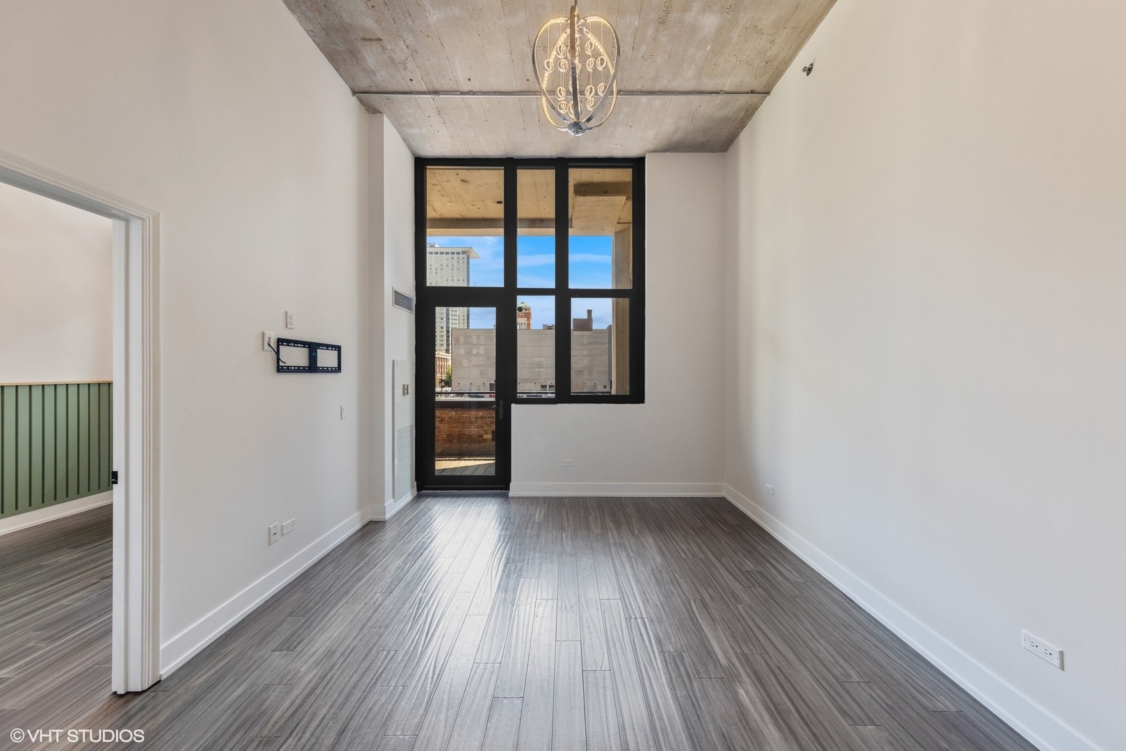 320 East 21st Street, Unit 215 Chicago, IL 60616 - Photo 10 of 25 a view of an empty room with wooden floor and a window
