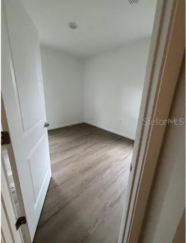 an empty room with wooden floor and door
