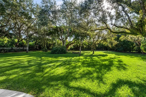 a view of green field with trees in the background