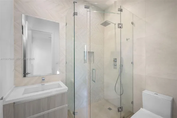 a bathroom with a sink a toilet and shower