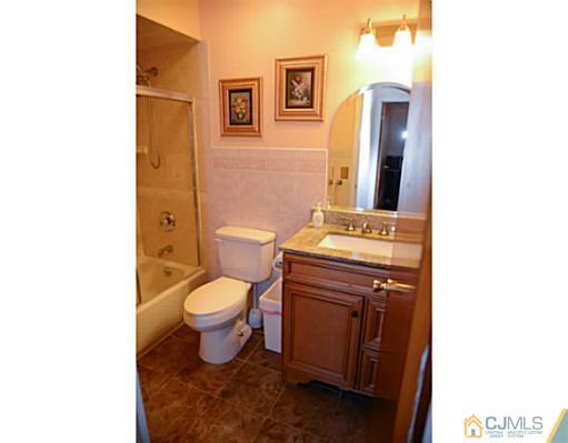 56 Meyer Road Edison, NJ 08817 - Photo 3 of 24 a bathroom with a toilet a sink and mirror
