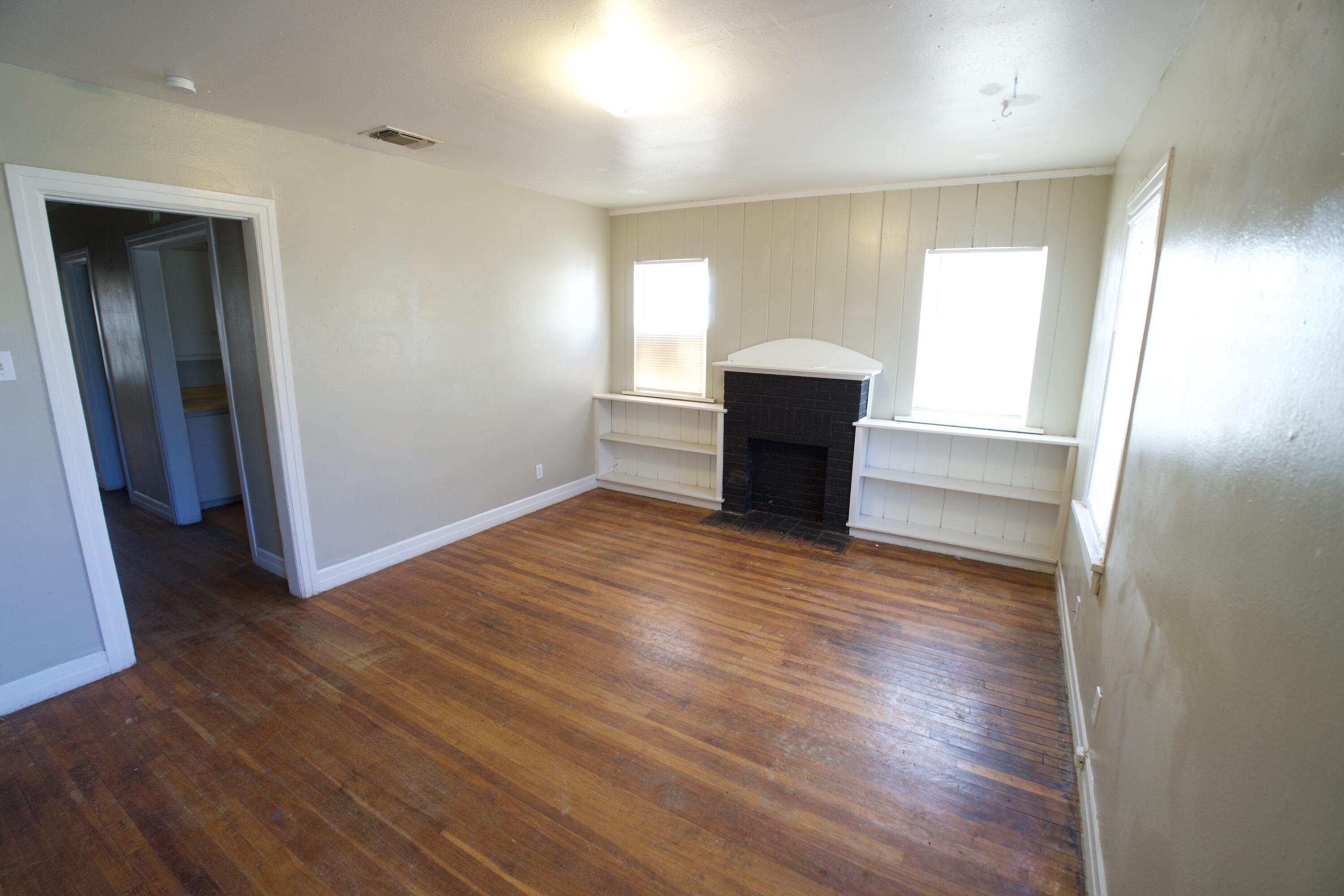 1919 17th Street Lubbock, TX 79401 - Photo 6 of 13 an empty room with wooden floor and windows