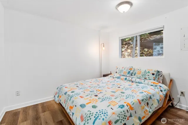 a bedroom with a bed and painting on the wall