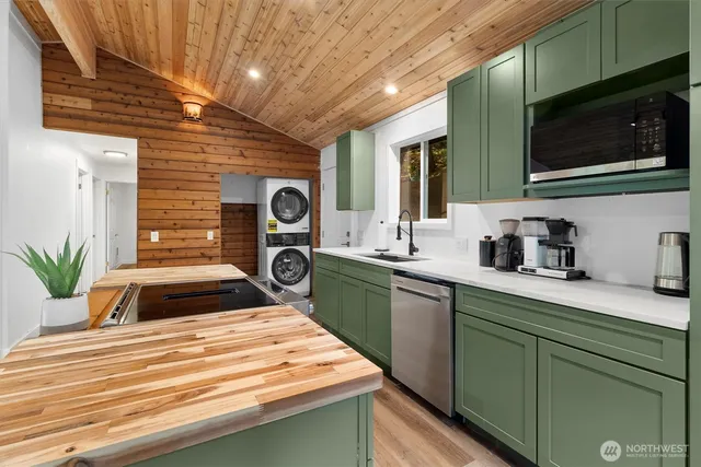 a kitchen with kitchen island white cabinets stainless steel appliances and sink