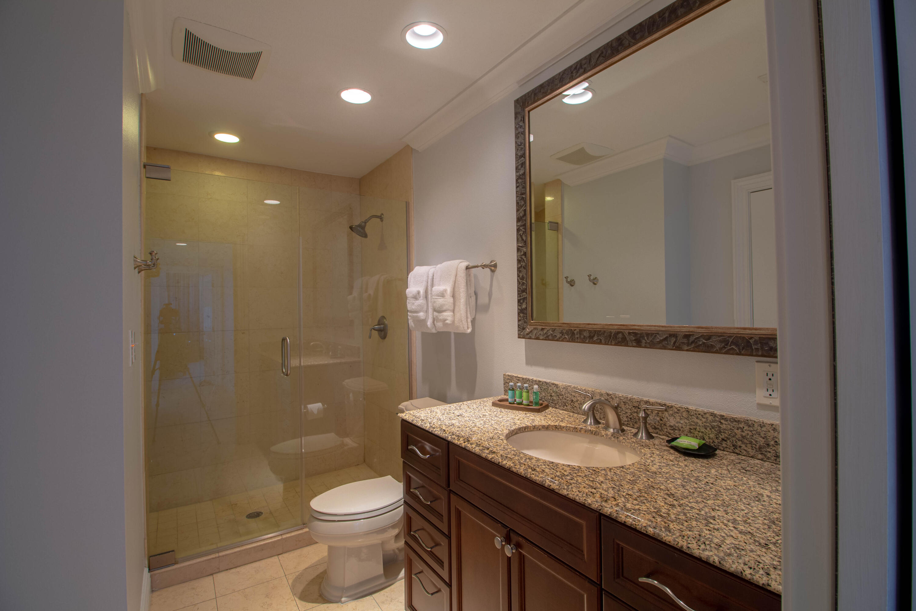 10 Harbor Boulevard, Unit E707H Destin, FL 32541 - Photo 11 of 28 a bathroom with a granite countertop sink a toilet a mirror and shower