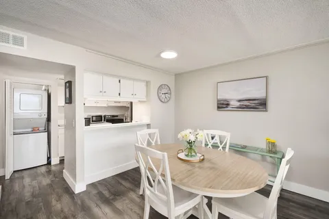 a kitchen with stainless steel appliances a dining table and chairs