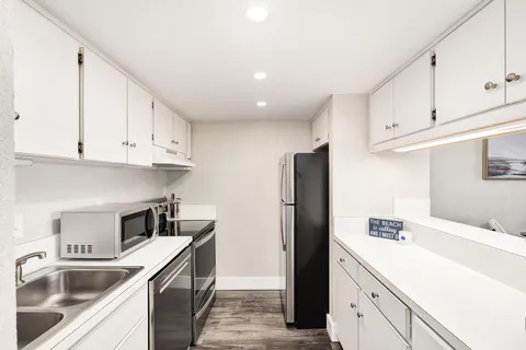 a kitchen with a sink a refrigerator and cabinets
