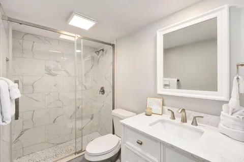 a bathroom with a sink a toilet and shower