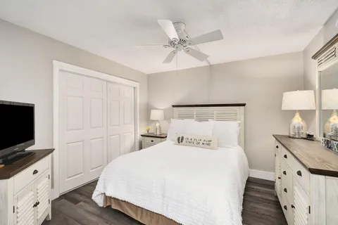 a bedroom with a bed and a flat tv screen on dresser